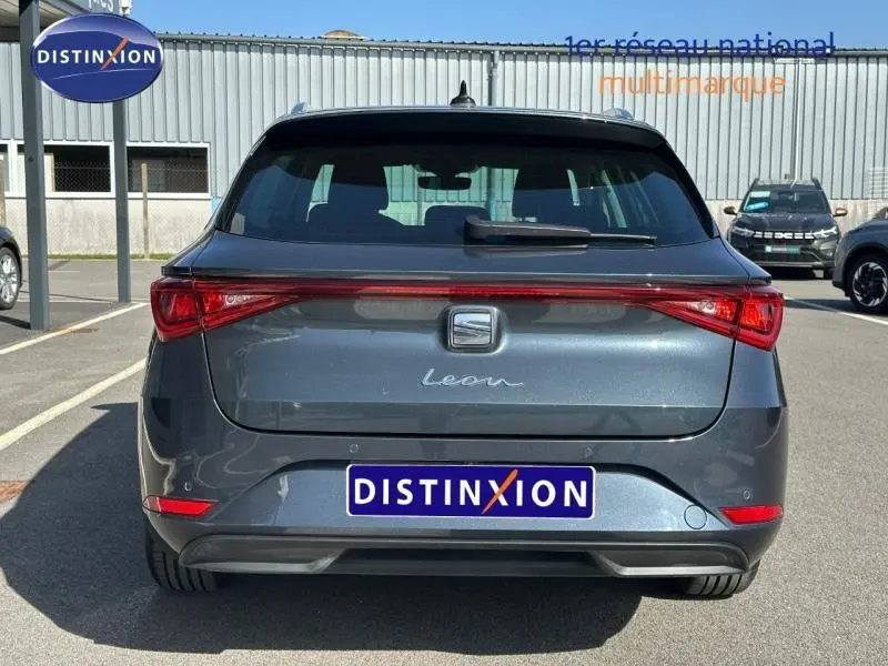 Vue arrière d'une SEAT LEON ST 2.0 TDI 115ch STYLE XL 2025 en gris magnétique métallisé, avec feux arrière étirés et logo central.