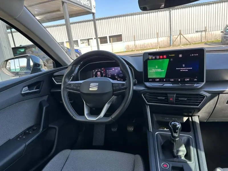 Vue intérieure avant du tableau de bord et volant de la SEAT LEON ST gris métallisé avec écran tactile et boîte manuelle.