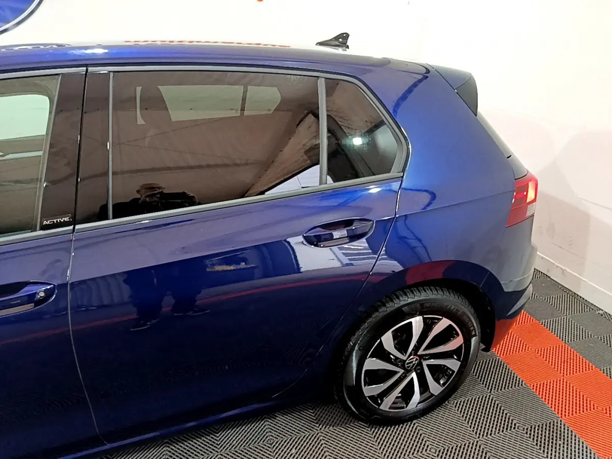 Vue latérale côté droit d'une Volkswagen Golf 1.0 TSI Active bleu avec jante alliage et vitres teintées.