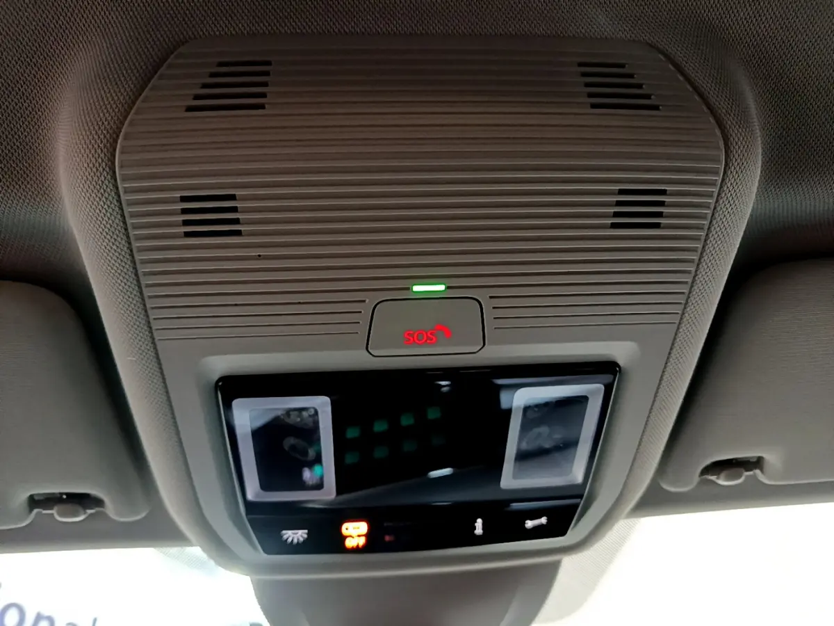Vue en gros plan du plafonnier beige avec bouton SOS rouge et éclairage intérieur d'une Volkswagen Golf bleue 2022