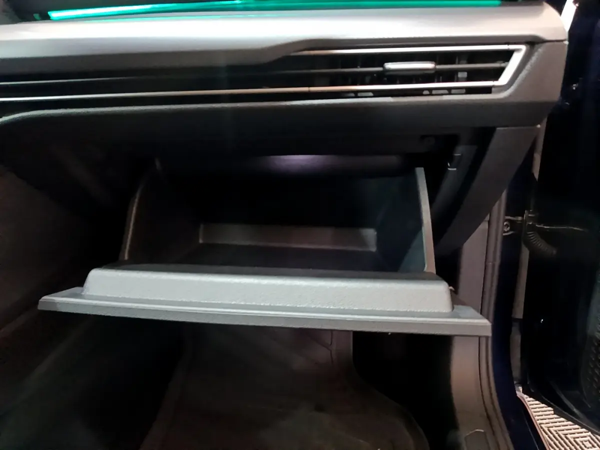 Gros plan sur la boîte à gants ouverte côté passager d'une Volkswagen Golf 1.0 TSI bleu 2022.