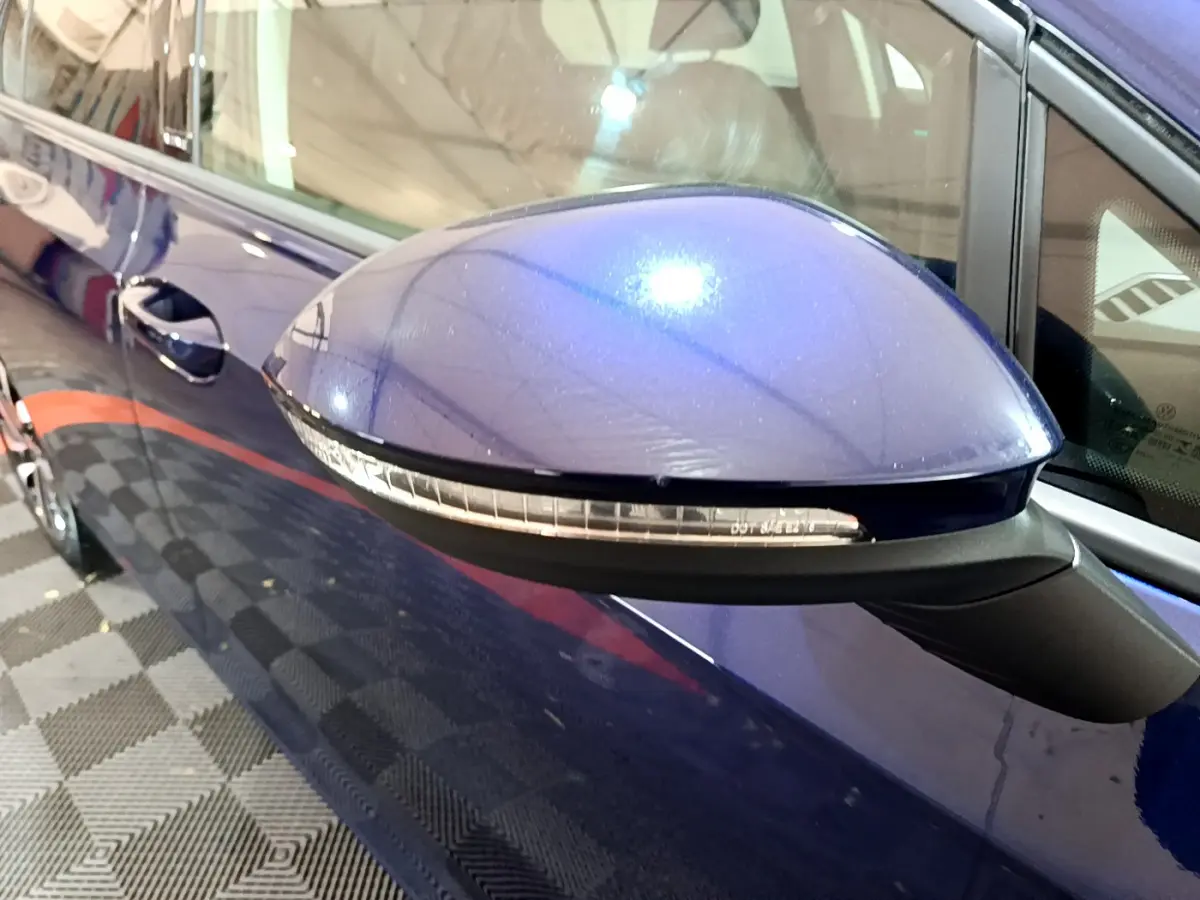 Rétroviseur droit bleu métallisé de la Volkswagen Golf 1.0 TSI 2022 avec clignotant intégré, vue rapprochée côté passager.