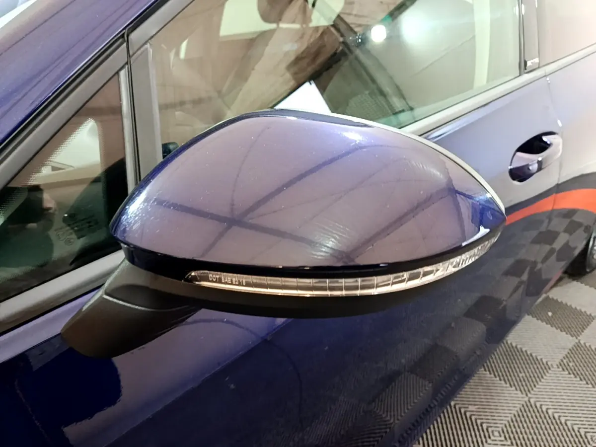 Rétroviseur côté gauche bleu brillant de la Volkswagen Golf 1.0 TSI 2022 avec clignotant intégré, vue rapprochée.