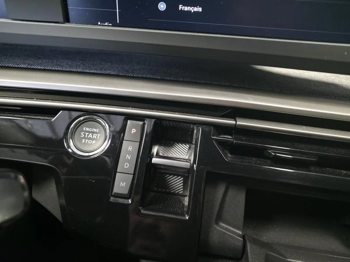 Gros plan sur la console centrale noire laquée du Peugeot 3008 2025 avec bouton start/stop et commandes de boîte auto.