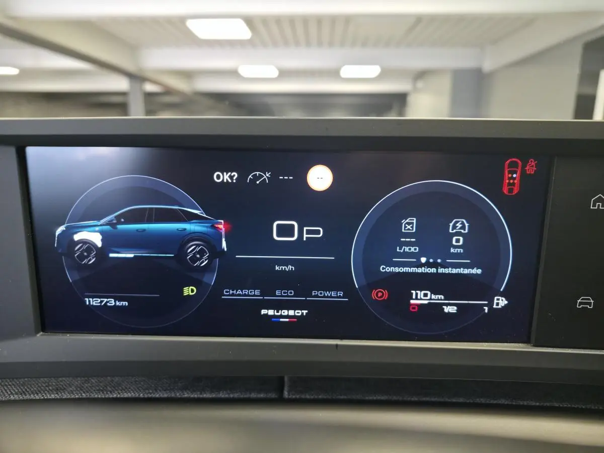 Affichage numérique du tableau de bord du Peugeot 3008 hybride, montrant la silhouette latérale bleue du véhicule et les données de consommation.
