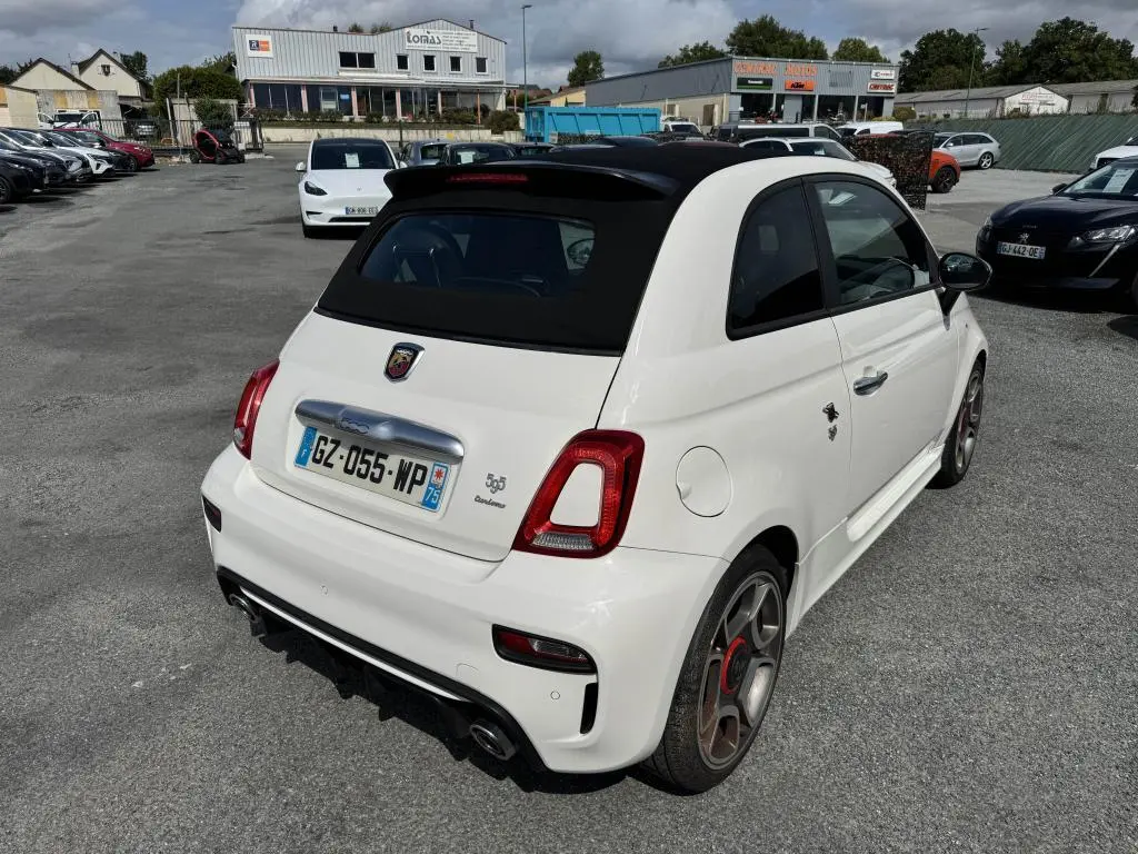 Vue 3/4 arrière droite de l'Abarth 595C Turismo blanche avec toit noir et double sortie d'échappement chromée.