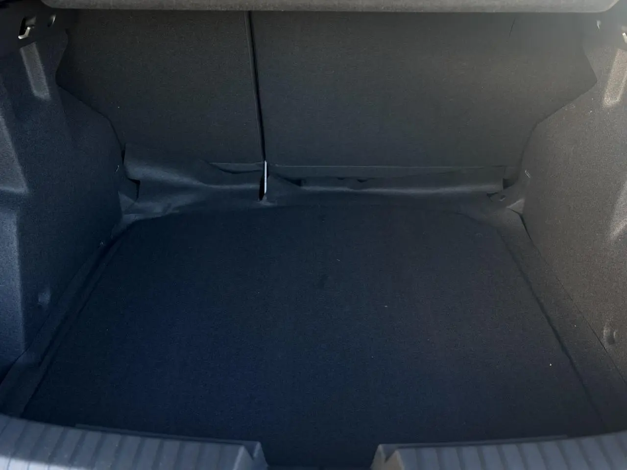 Coffre vide vu de face du Dacia Duster ECO-G 120 Auto Extrême gris Schiste, intérieur noir simple et spacieux.