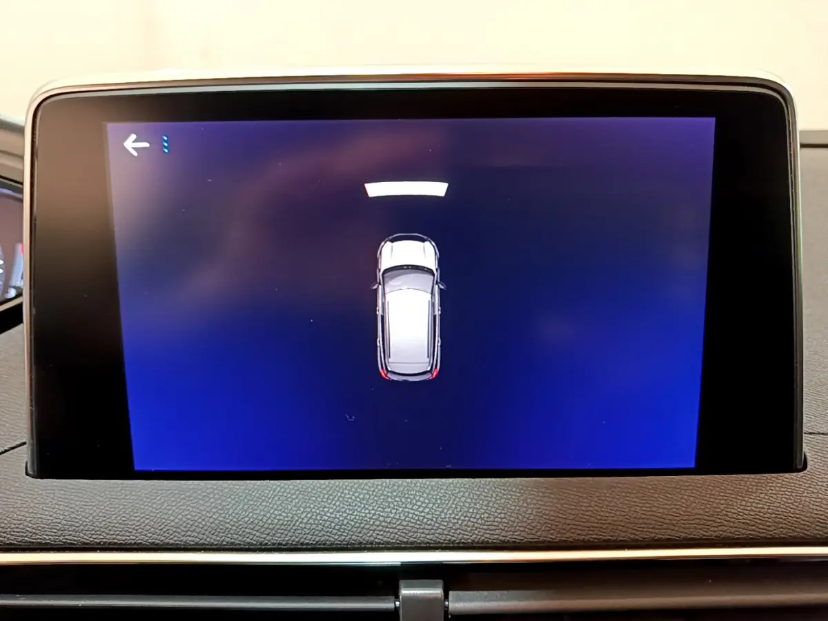 Écran tactile intérieur affichant la vue de dessus du Peugeot 3008 blanc en mode assistance au stationnement.