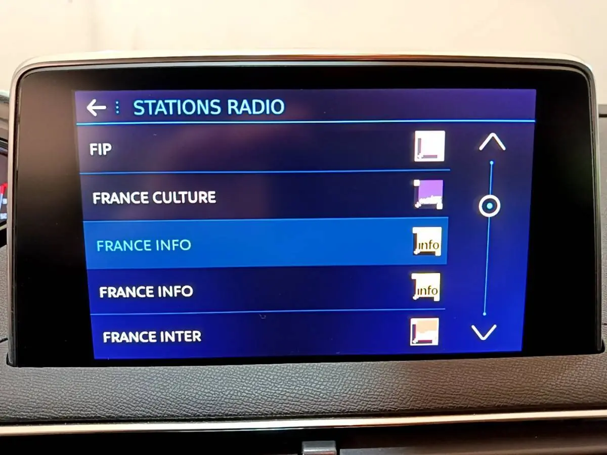 Écran tactile central affichant la liste des stations radio dans l'habitacle d'un Peugeot 3008 blanc.