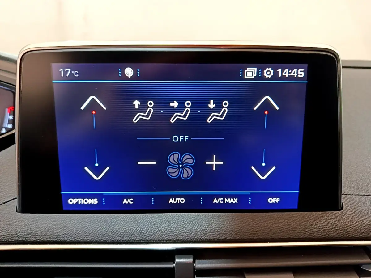 Écran tactile central affichant les commandes de climatisation du Peugeot 3008, tableau de bord noir.