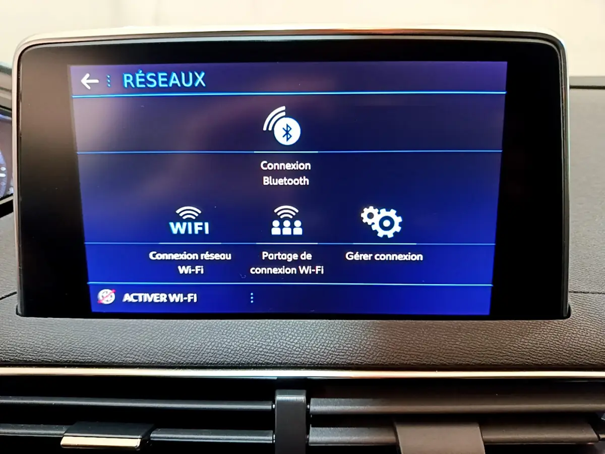 Écran tactile central affichant les options réseau Bluetooth et Wi-Fi dans l'habitacle du Peugeot 3008 blanc.