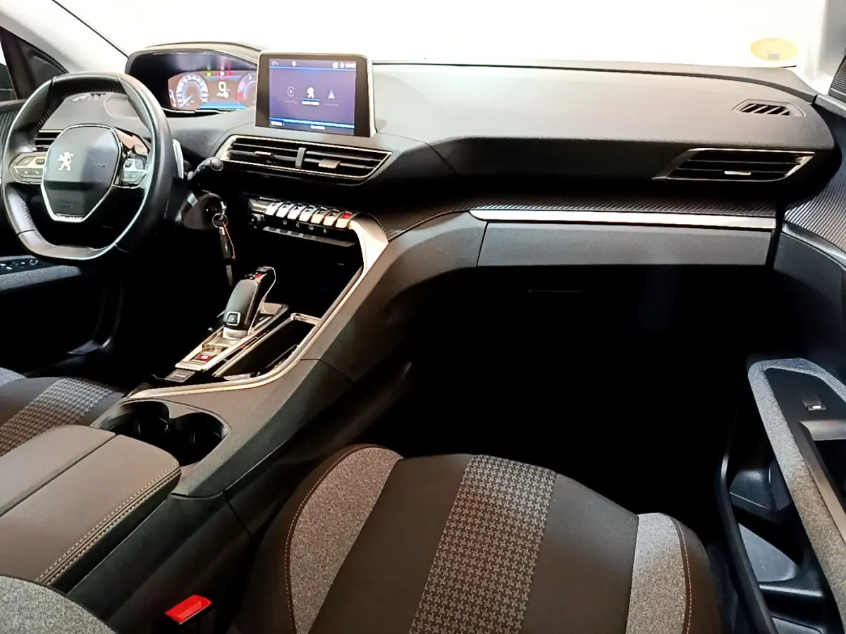 Intérieur du Peugeot 3008 2020 vu côté passager, tableau de bord moderne avec écran tactile et volant cuir noir.