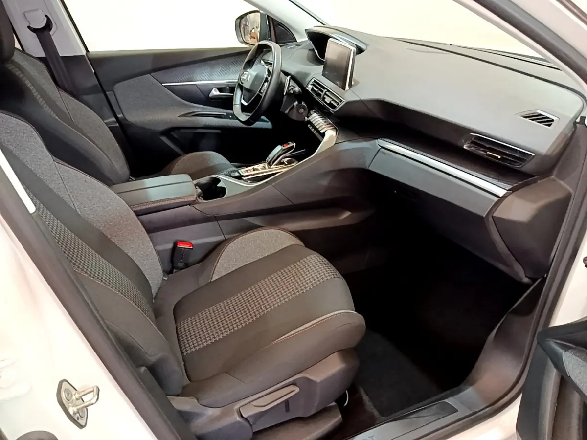 Intérieur avant droit du Peugeot 3008 blanc 2020, sièges tissu gris et tableau de bord avec écran tactile central.