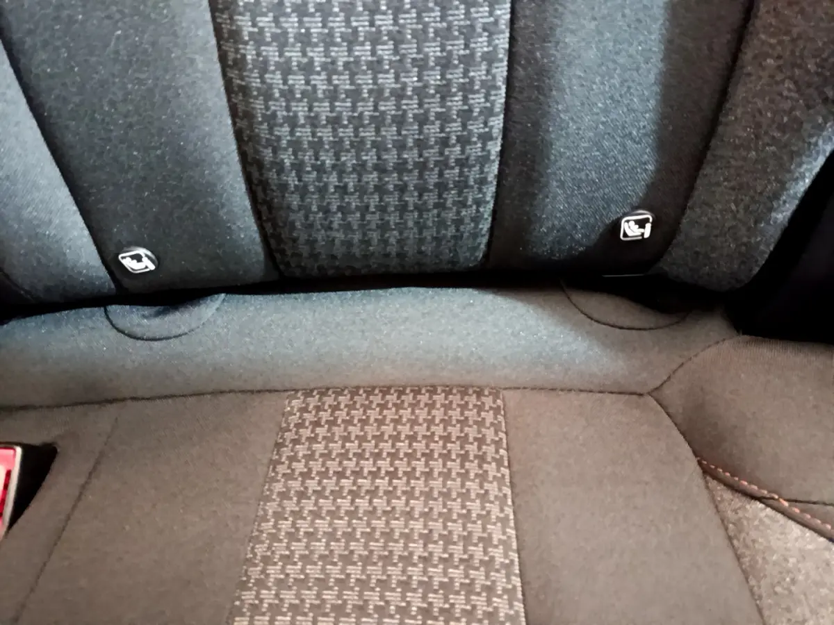 Gros plan sur la banquette arrière tissu gris du Peugeot 3008, avec fixations Isofix visibles sur les côtés.