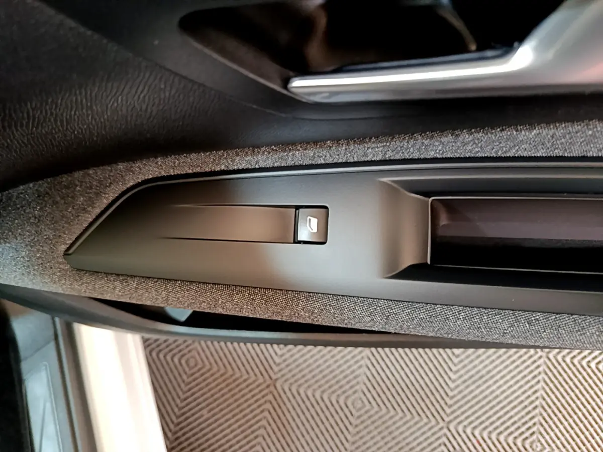 Détail de la commande de verrouillage sur la portière côté conducteur d'un Peugeot 3008 blanc 2020.
