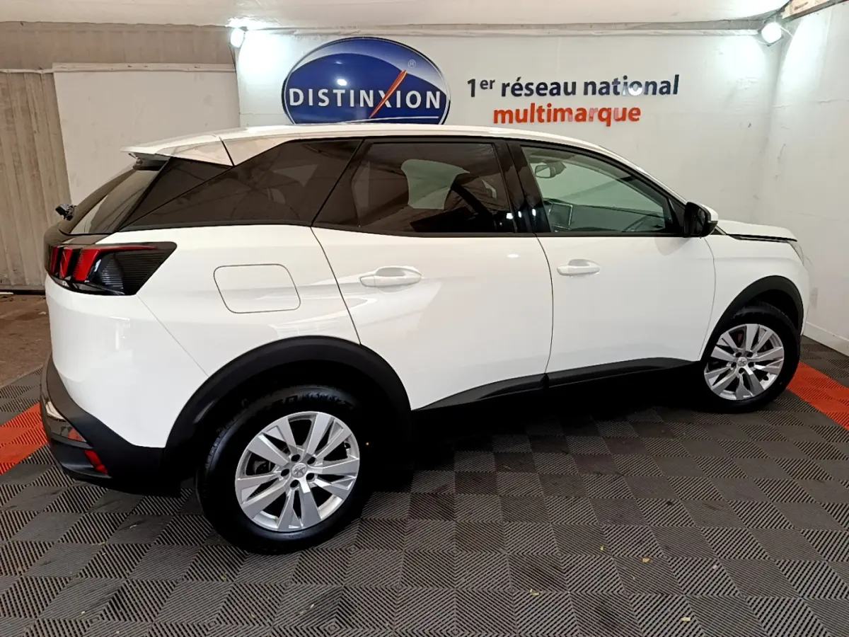 Peugeot 3008 blanc vue de profil côté gauche, avec vitres teintées et jantes alliage en intérieur showroom.