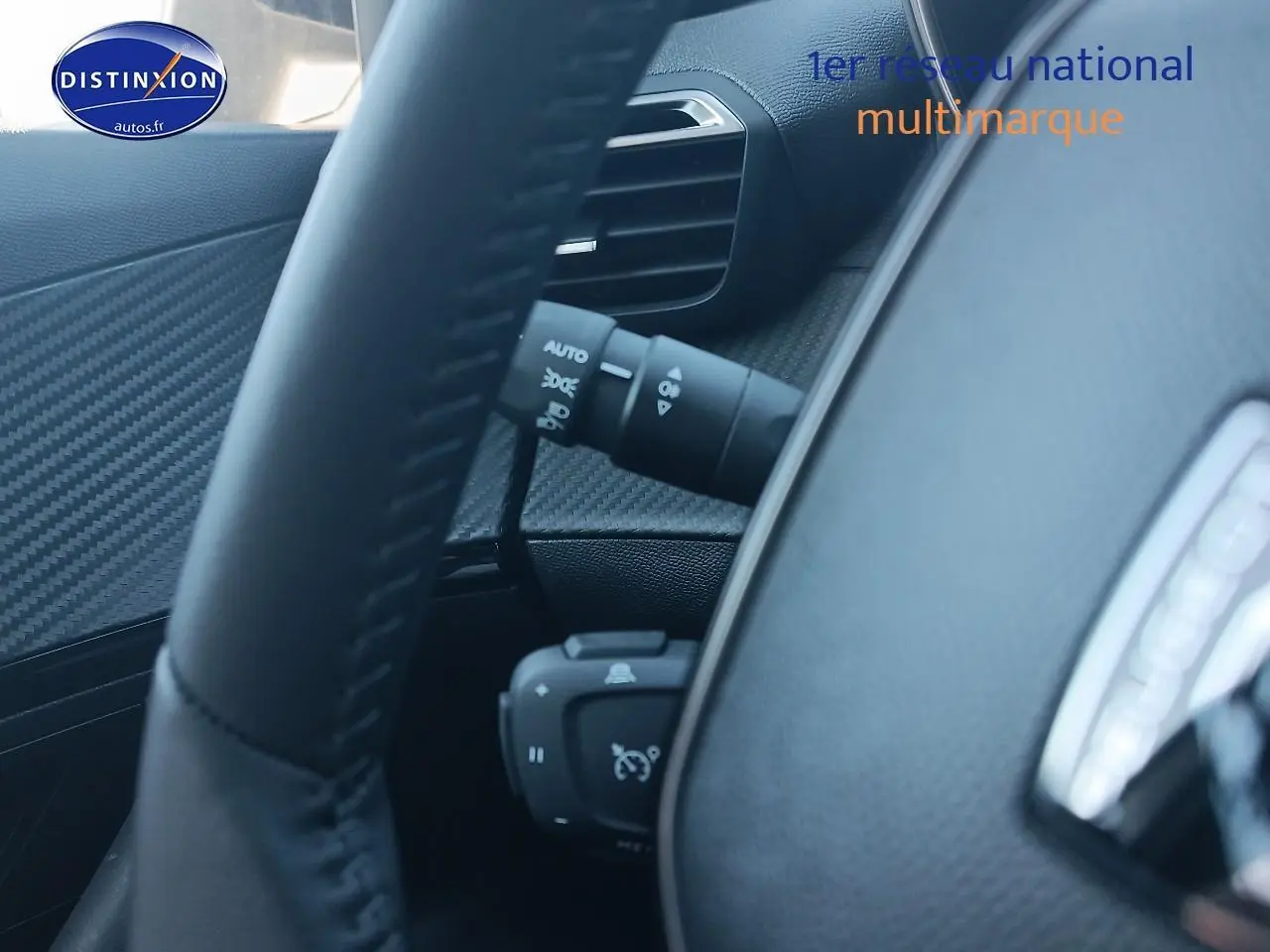 Gros plan sur le volant et la commande de régulateur de vitesse du Peugeot 2008 gris artense, intérieur noir.