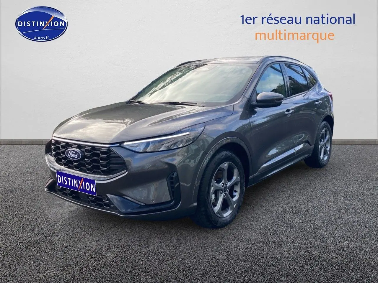 Ford Kuga gris métallisé vu en 3/4 avant droit avec calandre noire et jantes alliage cinq branches.