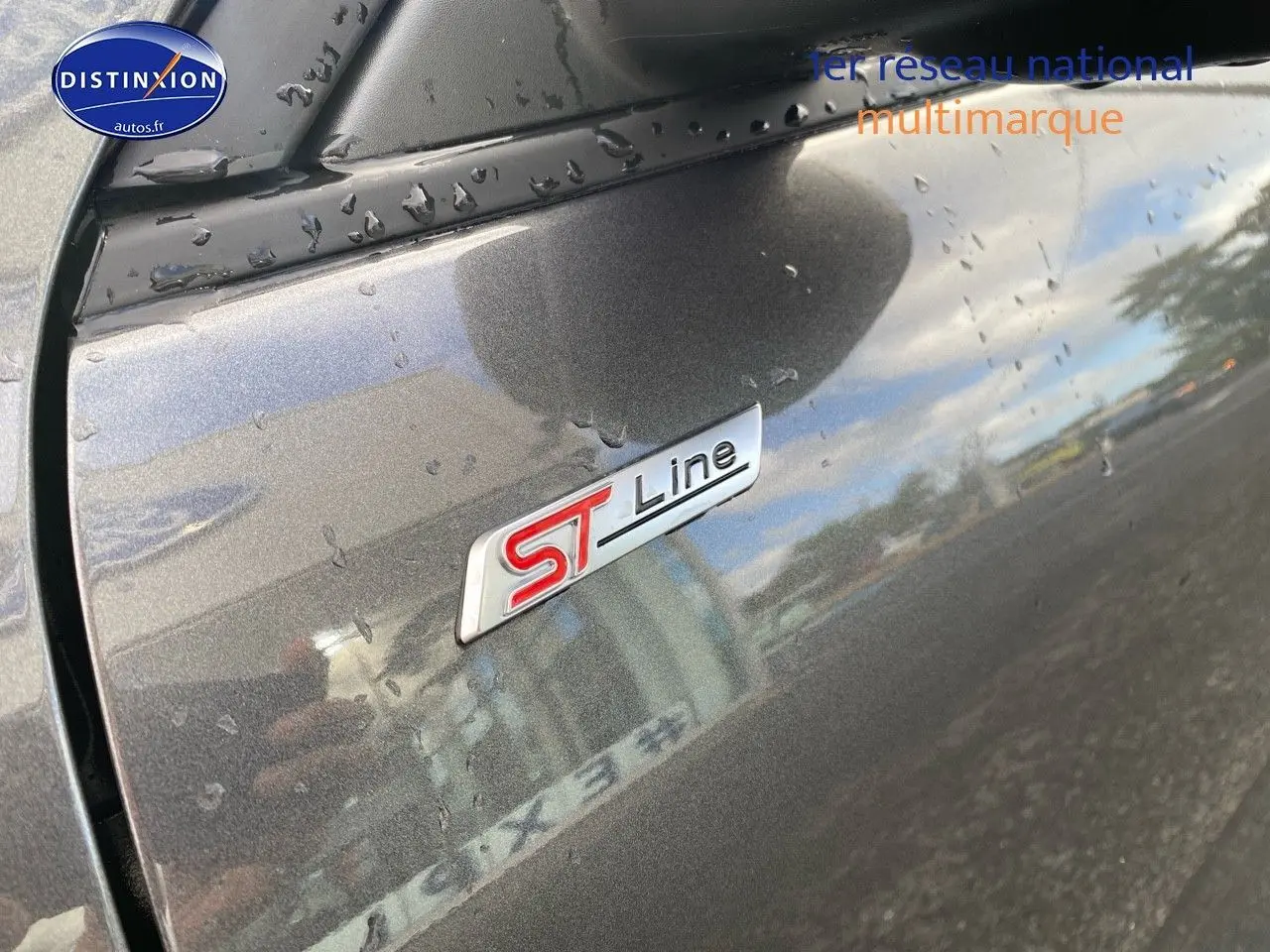 Gros plan sur l’écusson ST-Line sur la porte côté gauche d’un Ford Kuga gris Magnetic Fashion métallisé.