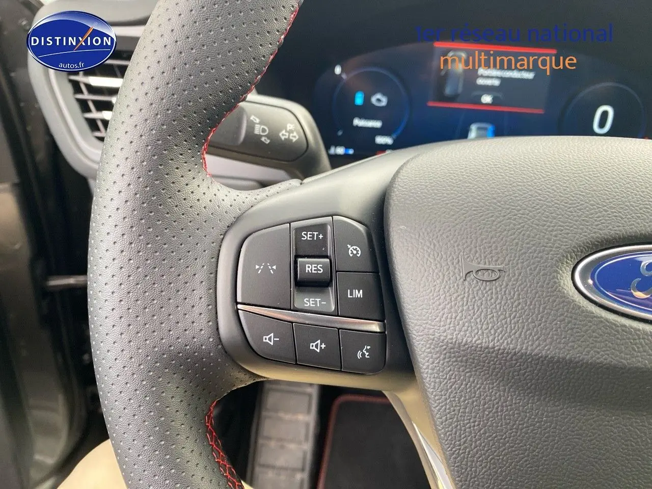 Gros plan sur le volant perforé avec commandes multifonctions du Ford Kuga 2025 gris Magnetic Fashion.