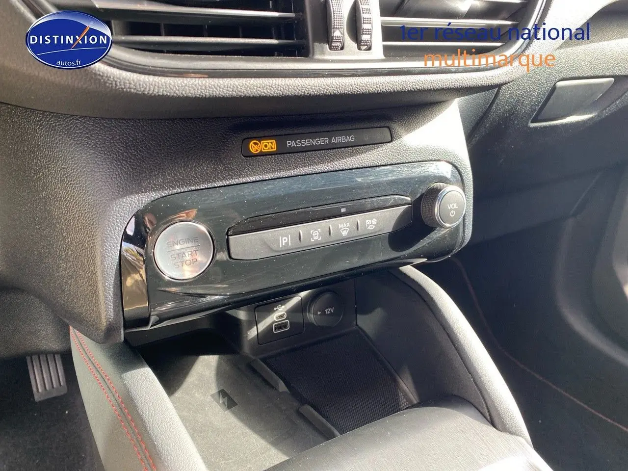 Détail de la console centrale noire du Ford Kuga 2025 avec bouton start/stop et commandes multimédia visibles.