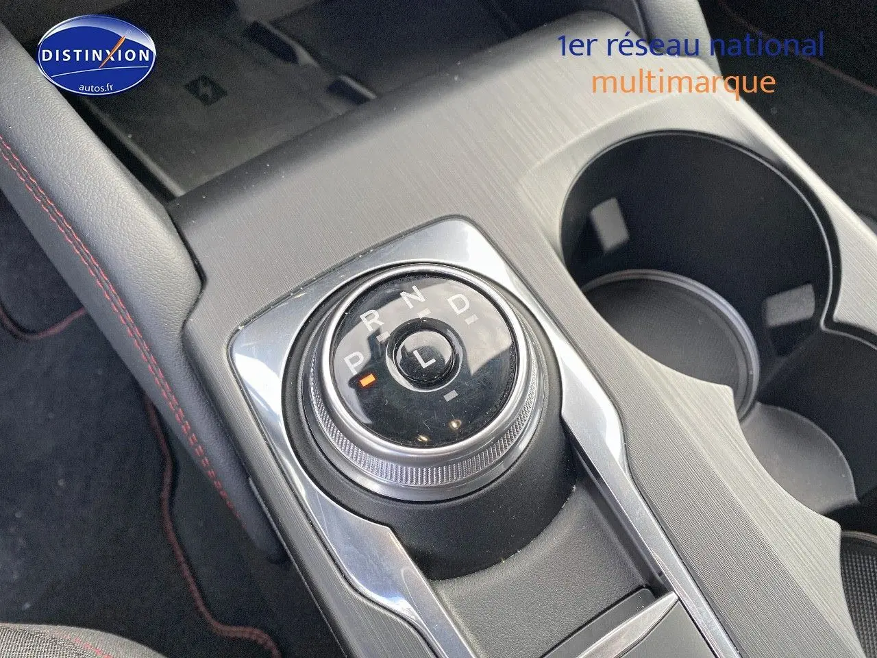 Gros plan sur la molette de sélection de la boîte automatique du Ford Kuga 2025, entourée de console grise et porte-gobelets.