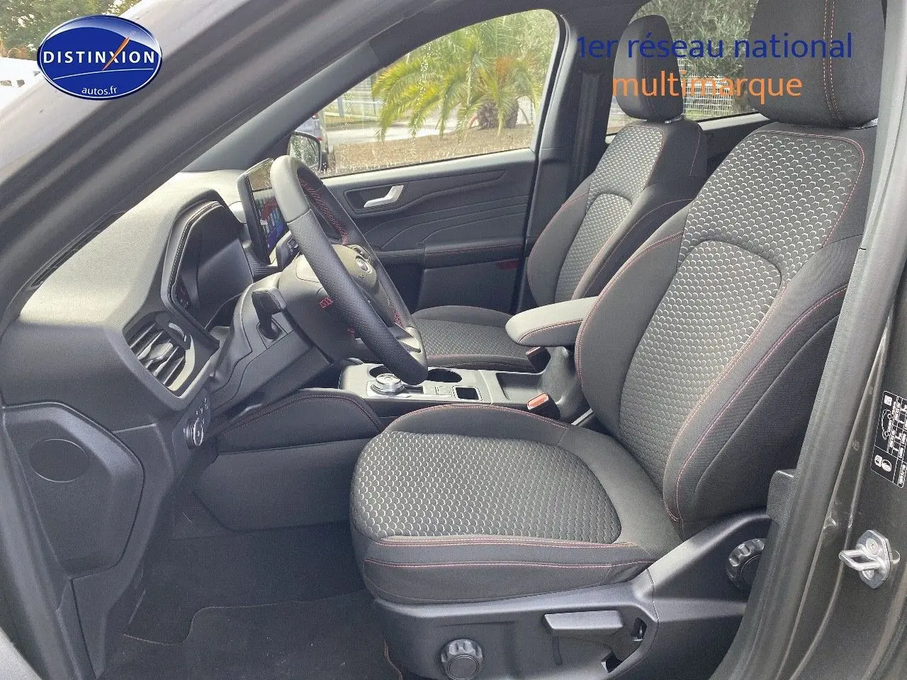Vue intérieure côté conducteur du Ford Kuga 2025 gris Magnetic, sièges tissu ST-Line avec surpiqûres rouges.