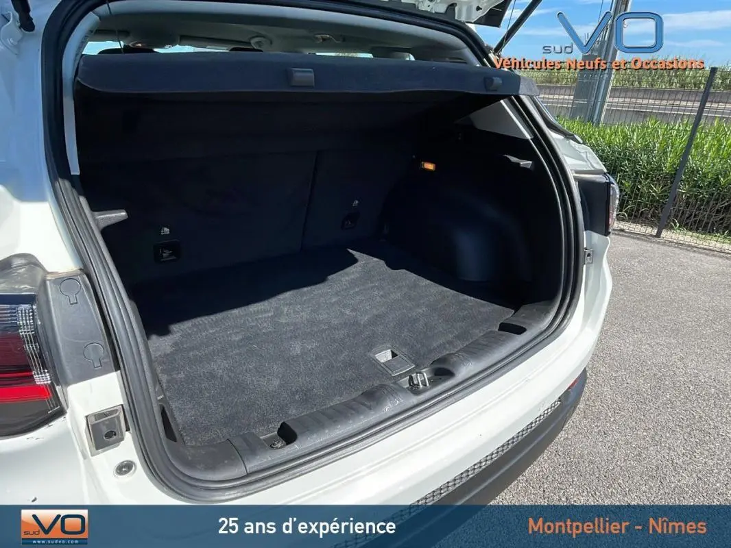 Coffre ouvert vu de l'arrière d'un Jeep Compass blanc 2024, montrant un espace de chargement propre et spacieux.