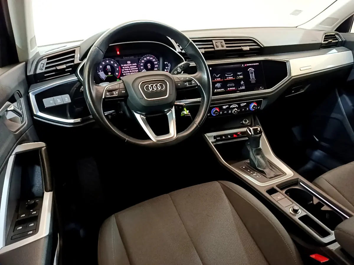 Vue intérieure de l'Audi Q3 Sportback 35 TFSI 150 MHEV 2021, tableau de bord et volant cuir noir multifonctions.