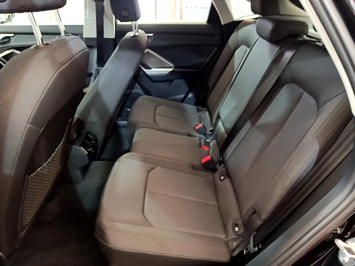 Vue côté droit de la banquette arrière noire de l'Audi Q3 Sportback 35 TFSI 150 MHEV 2021, sièges en tissu.