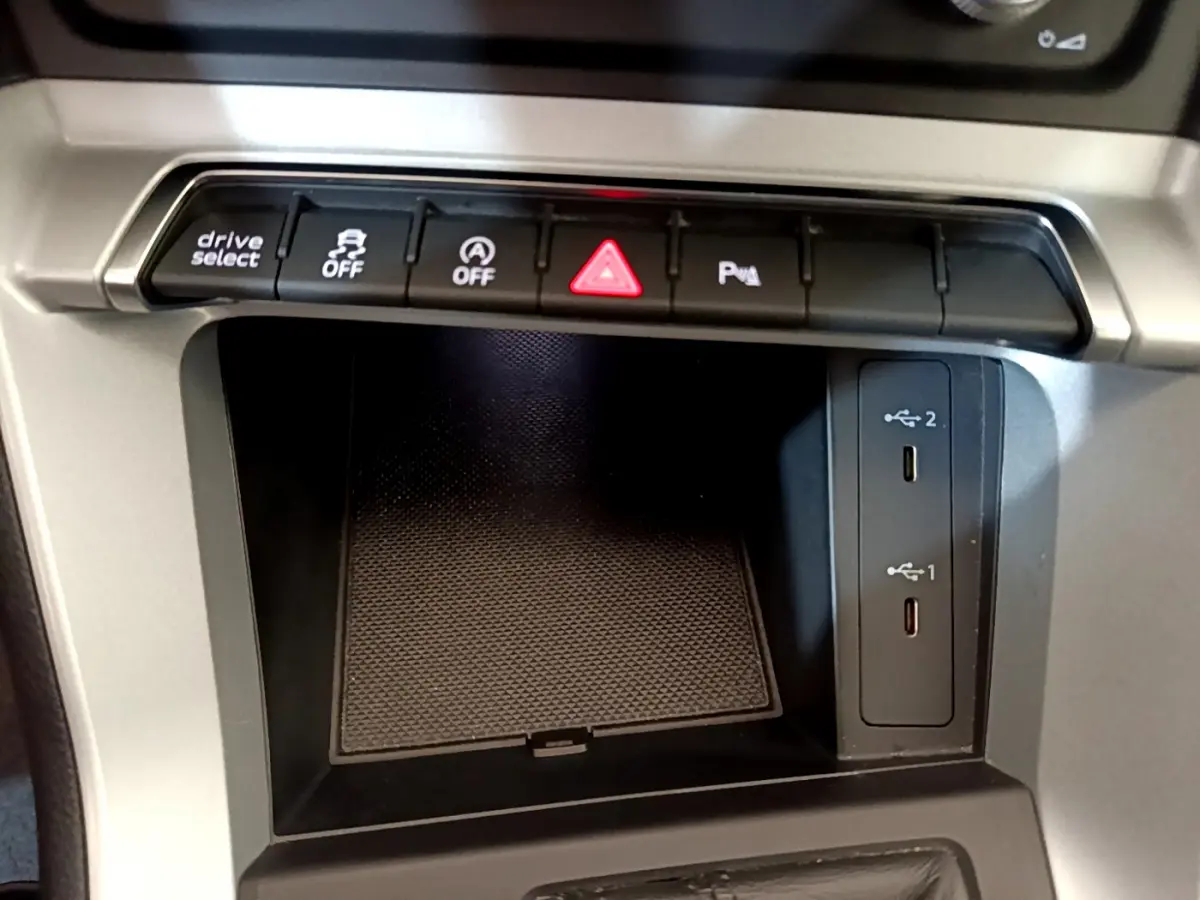 Gros plan sur la console centrale de l'Audi Q3 Sportback 35 TFSI 150 MHEV 2021, montrant les boutons de contrôle et ports USB.