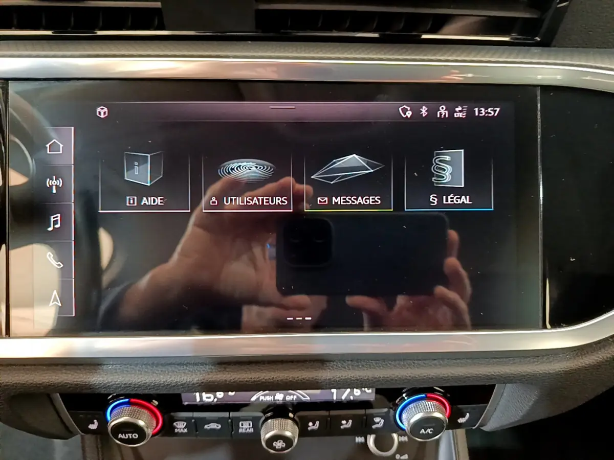 Écran tactile central affichant les menus d’aide et messages dans l’Audi Q3 Sportback noir, vue intérieure frontale.