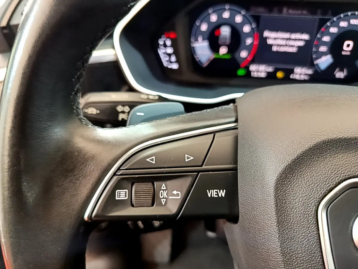 Gros plan sur le volant cuir noir de l'Audi Q3 Sportback 2021 avec commandes multifonctions et tableau de bord numérique.