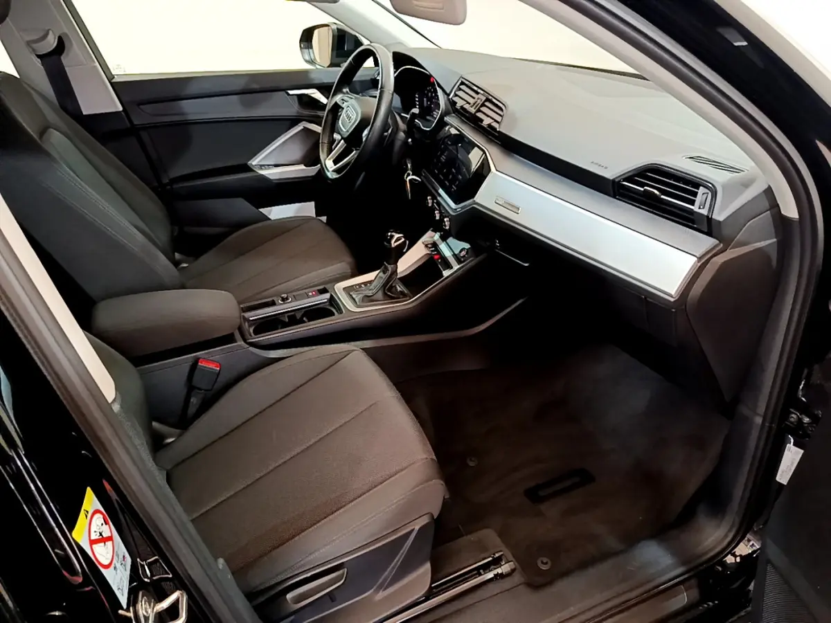 Intérieur noir de l'Audi Q3 Sportback 35 TFSI 2021, vue côté conducteur avec tableau de bord moderne et volant cuir.