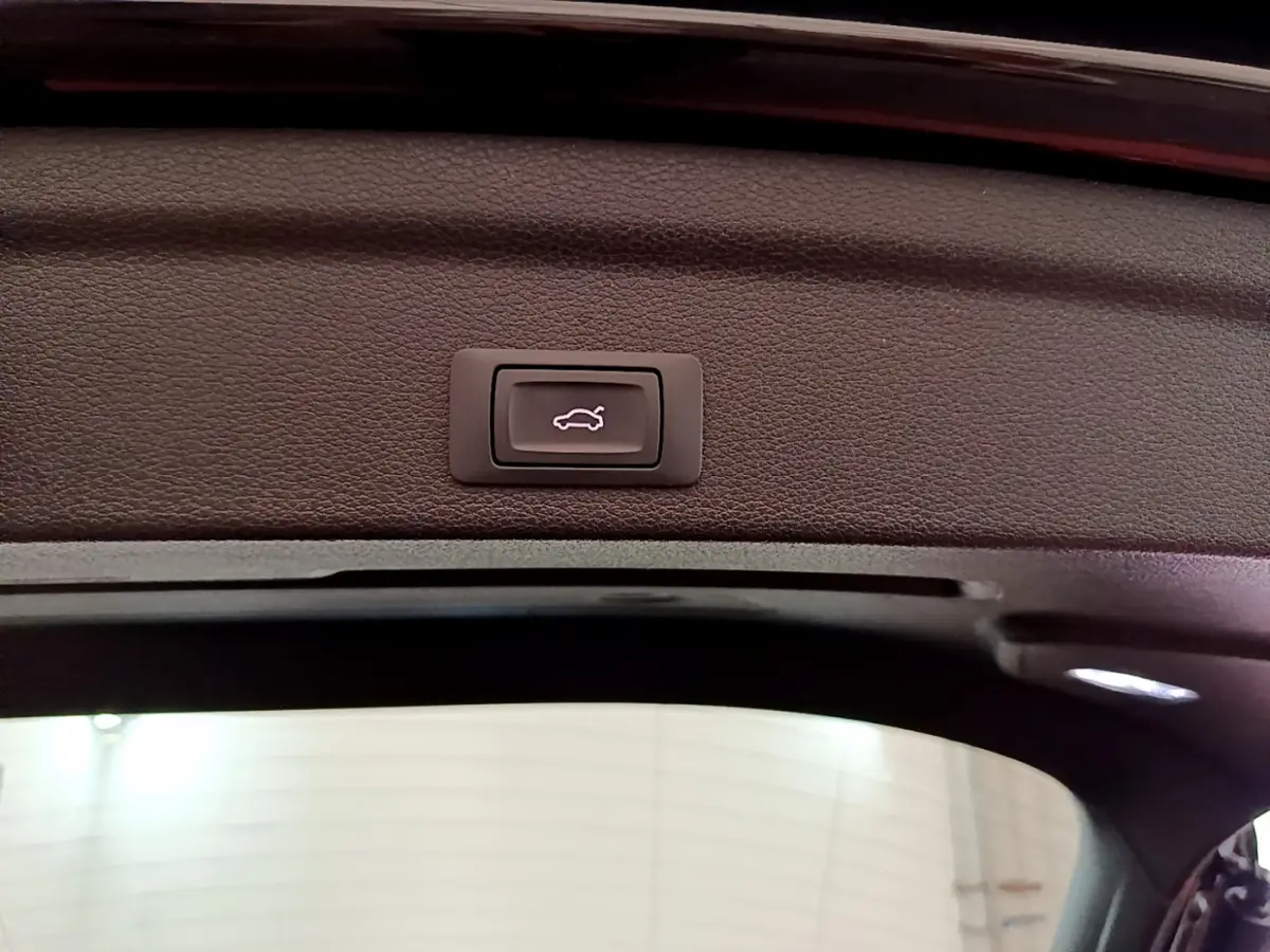 Bouton d'ouverture électrique du coffre sur le bord intérieur du hayon d'un Audi Q3 Sportback noir 2021.