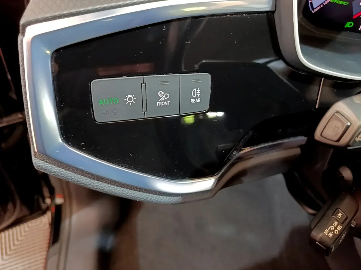 Gros plan sur les commandes d'éclairage noires et grises du tableau de bord côté gauche de l'Audi Q3 Sportback noir 2021.