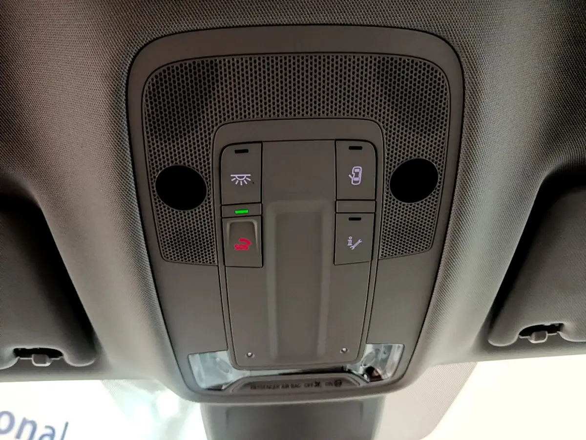 Vue en contre-plongée du panneau de commandes au plafond de l'Audi Q3 Sportback noir, avec boutons d'éclairage et appel d'urgence.