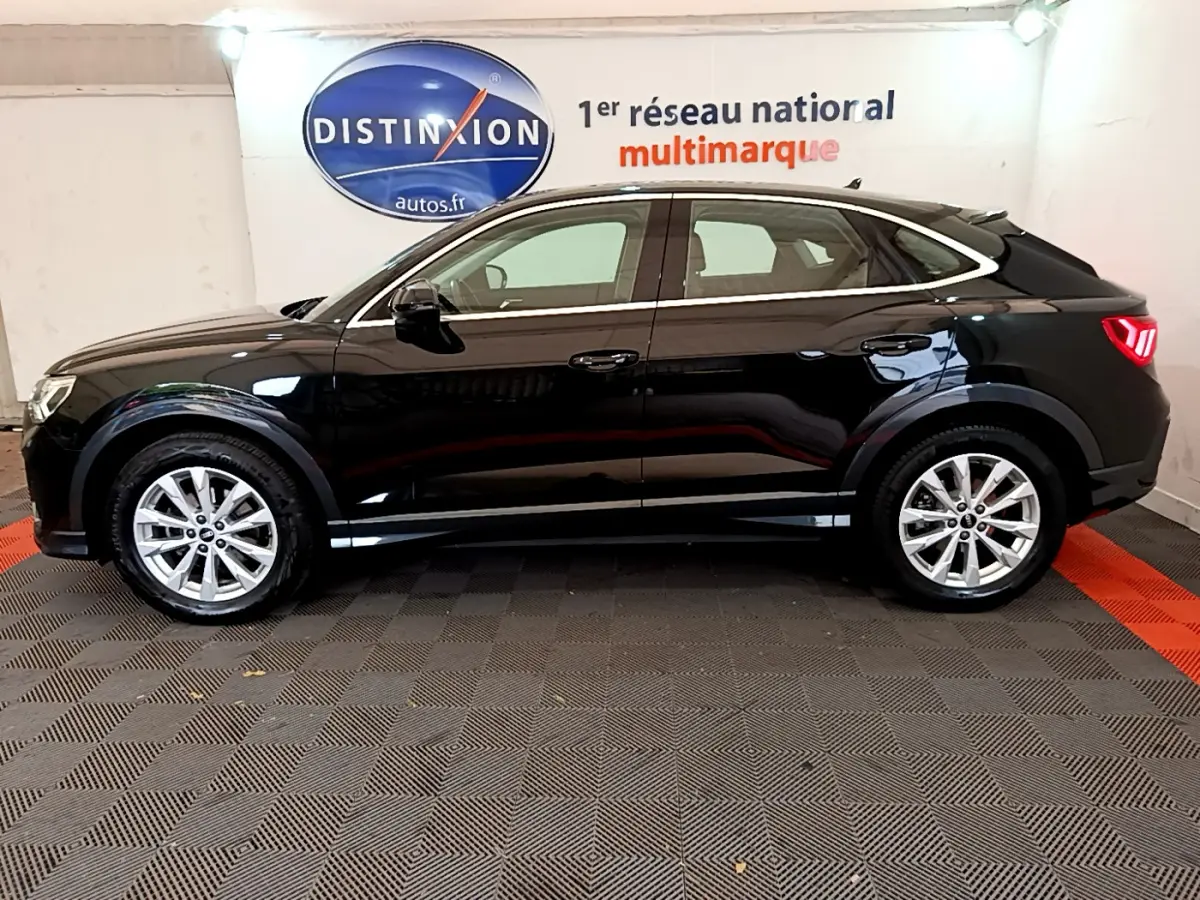 Audi Q3 Sportback noir vu de profil côté gauche, avec lignes fluides et feux arrière LED distinctifs.