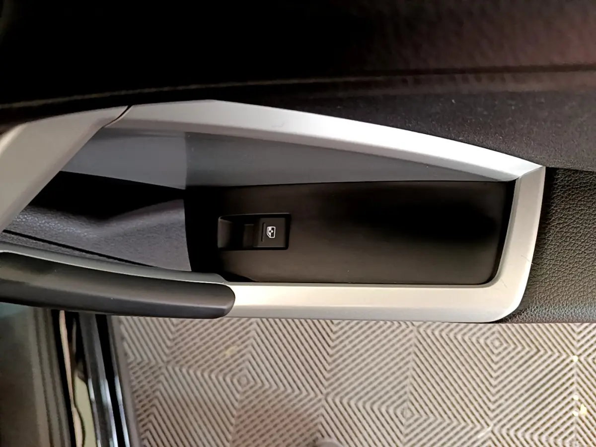 Gros plan sur la commande de lève-vitre côté conducteur dans l'habitacle noir de l'Audi Q3 Sportback 2021.