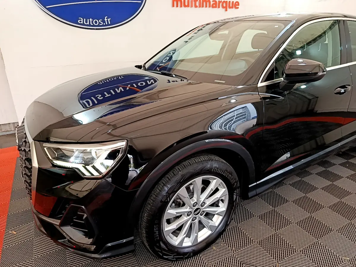 Vue 3/4 avant gauche d'un Audi Q3 Sportback noir brillant avec phares LED et jantes argentées.