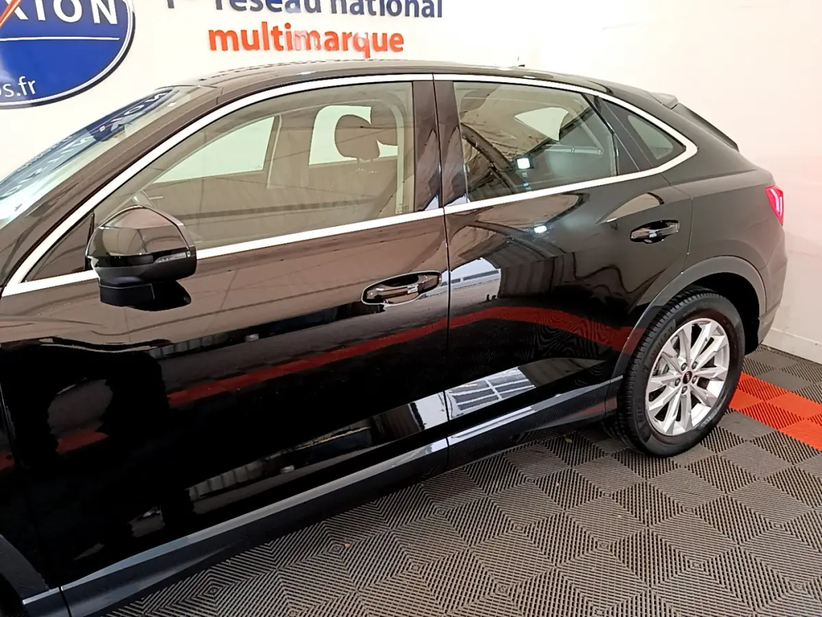 Profil côté gauche d'un Audi Q3 Sportback noir 2021, mettant en valeur ses lignes dynamiques et ses jantes alliage.