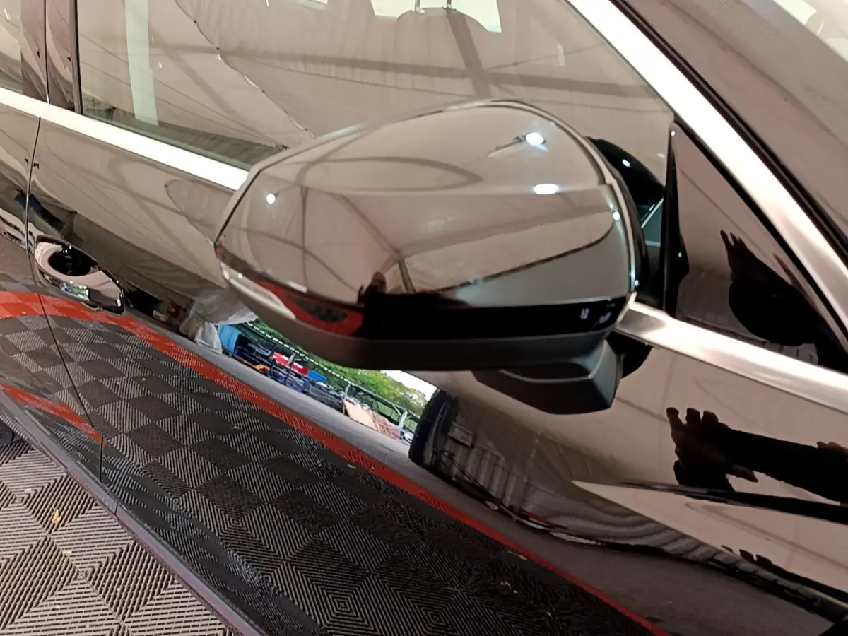 Rétroviseur côté gauche noir brillant de l'Audi Q3 Sportback 35 TFSI 150 MHEV S Tronic 7, reflet de l'environnement visible.