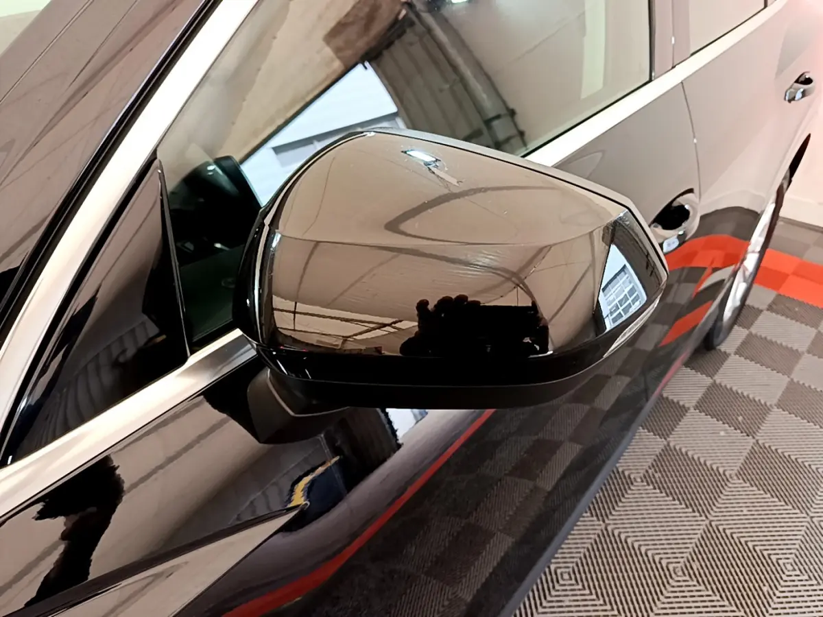 Rétroviseur côté gauche noir brillant de l'Audi Q3 Sportback 35 TFSI 2021 avec carrosserie noire vue en gros plan.