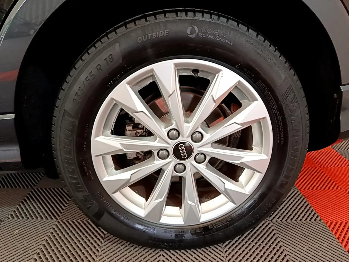 Gros plan sur la roue avant droite noire d'un Audi Q3 Sportback 35 TFSI 150 MHEV avec jante argentée à multiples branches