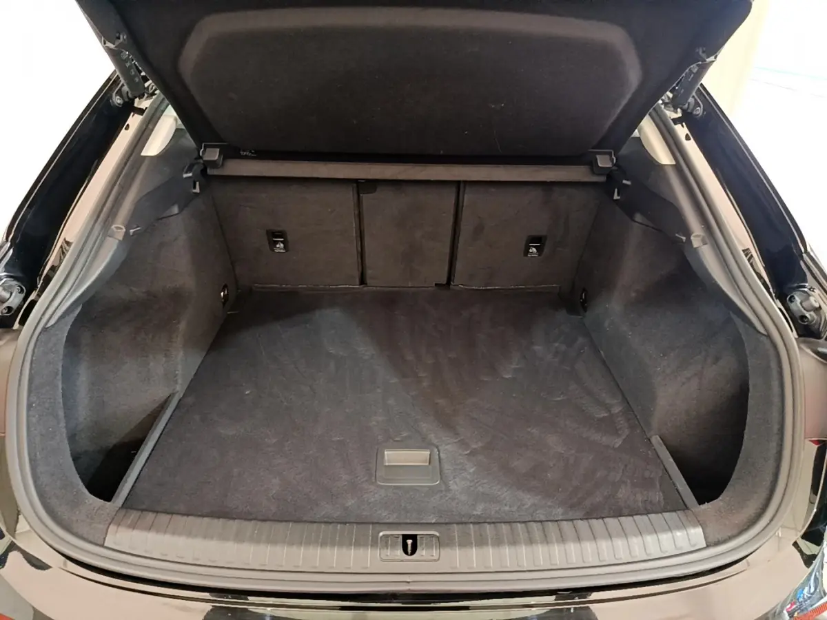 Coffre ouvert vu de l'arrière d'un Audi Q3 Sportback noir, espace de chargement propre et spacieux.