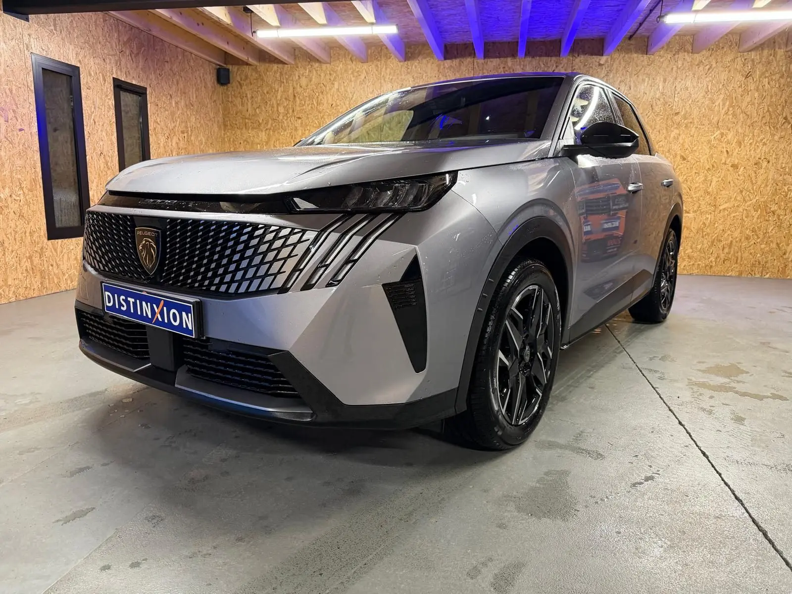 Peugeot 3008 1.2 Hybrid 136 Allure gris en 3/4 avant droit, avec calandre noire et jantes alliage distinctives.