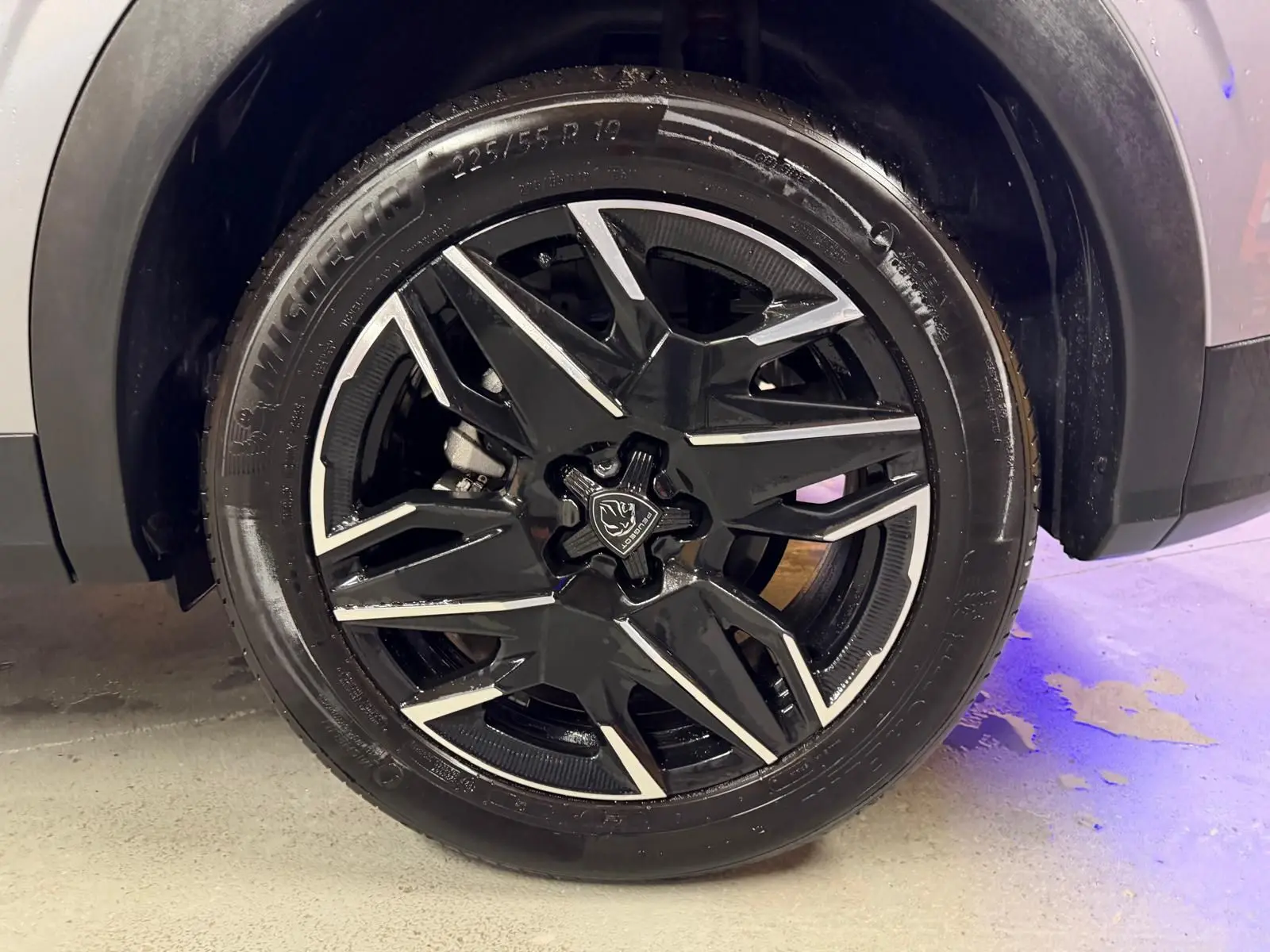 Gros plan sur la roue avant droite du Peugeot 3008 gris 2025, avec jante alliage noire et détails argentés.