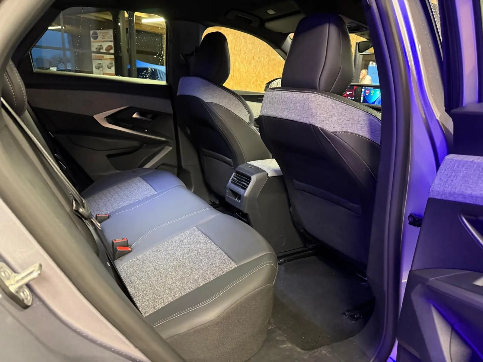 Vue intérieure côté arrière droit du Peugeot 3008 gris 2025, montrant les sièges arrière en tissu et cuir bicolore.