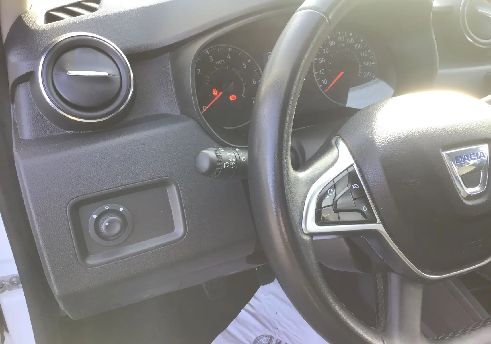 Vue intérieure côté conducteur du tableau de bord noir et volant du Dacia Duster blanc 2021, version diesel 4x2.