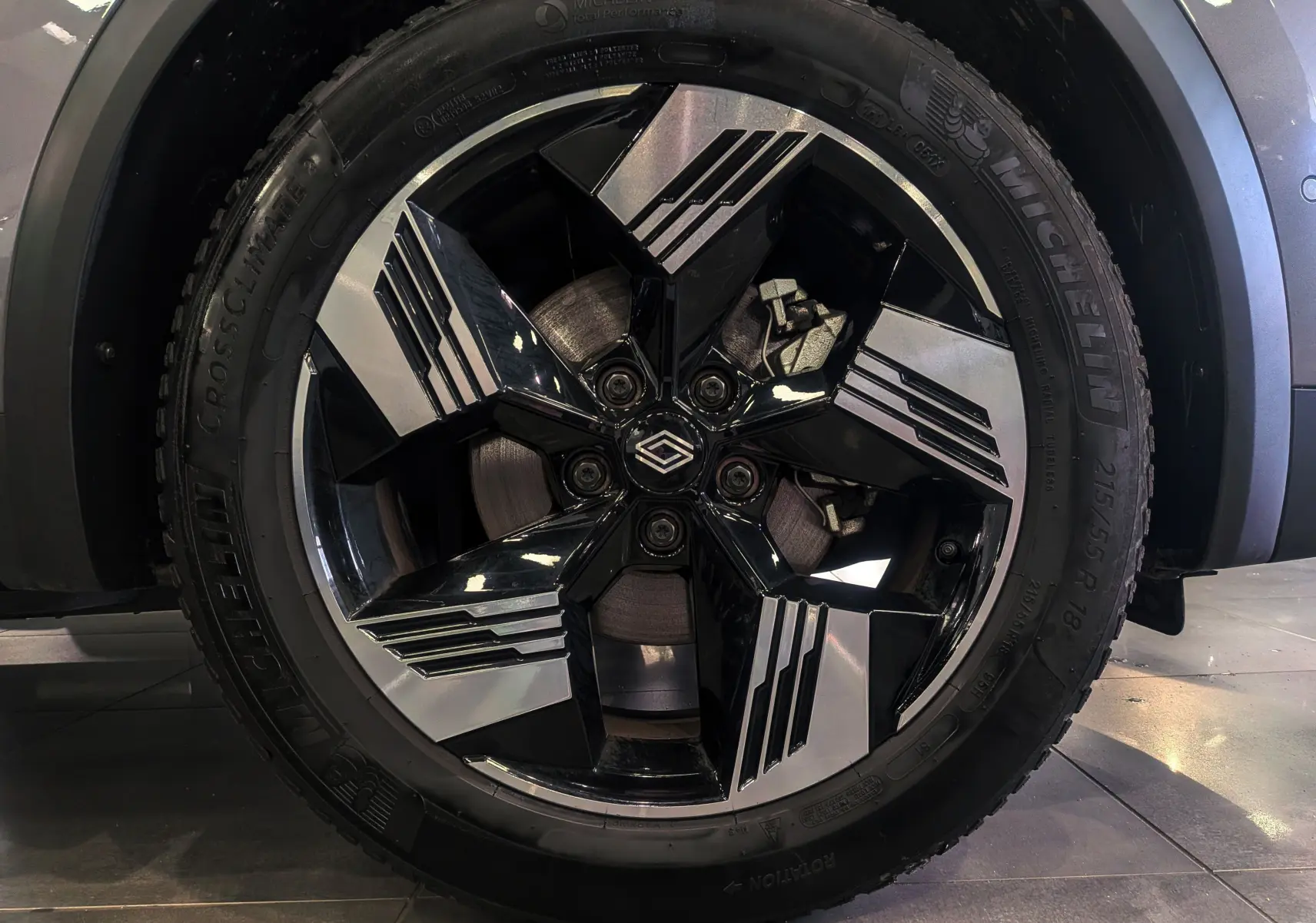 Gros plan sur la roue avant droite du Renault SYMBIOZ gris Cassiopé, mettant en valeur la jante noire et argentée au design moderne.